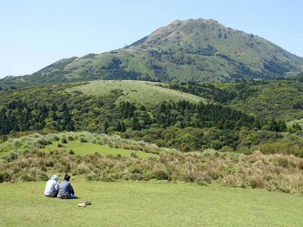台北・陽明山のおすすめスポット「擎天崗」で草原に座るカップル