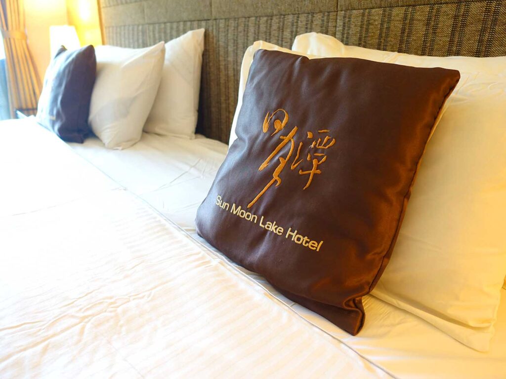 日月潭のおすすめホテル「日月潭大飯店」映月湖景和洋房のキングサイズベッドに置かれたクッション