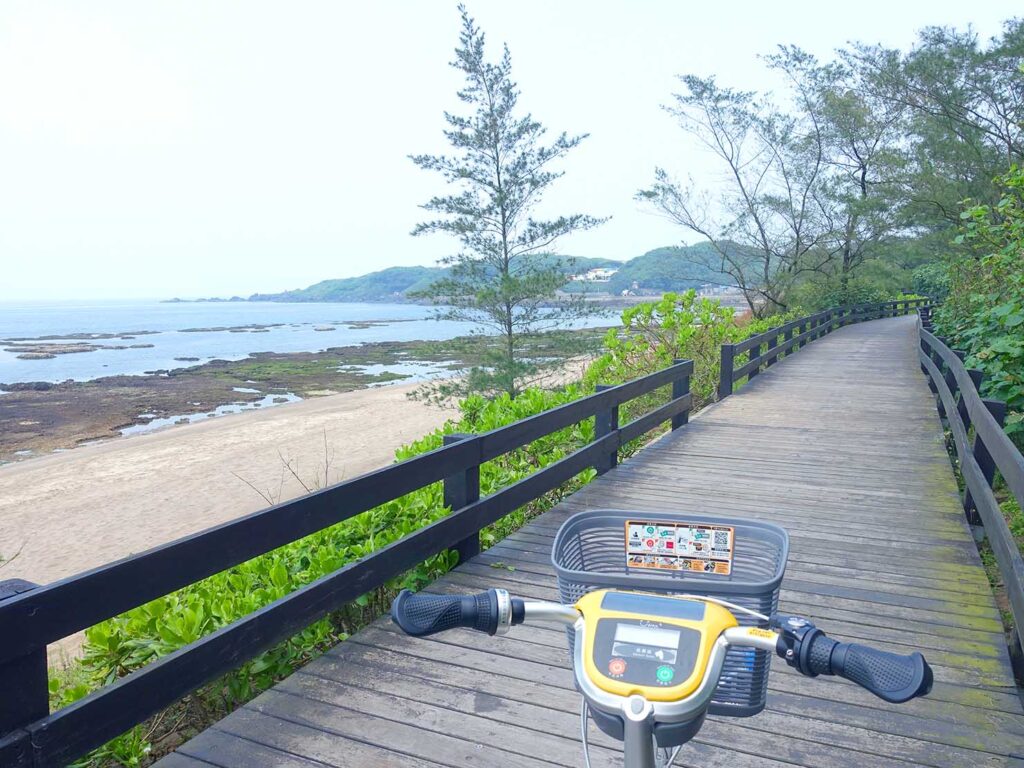 台北・白沙灣のサイクリングロード「雙灣自行車道」の木材で組まれた道を海沿いへ