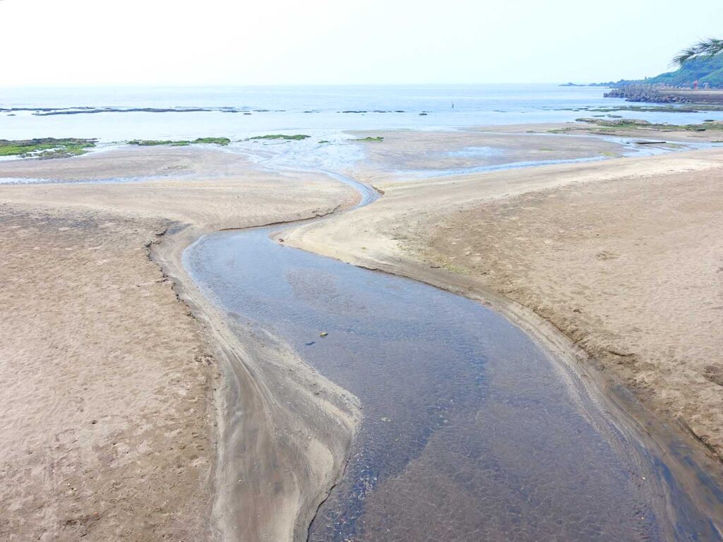 台北・白沙灣のサイクリングロード「雙灣自行車道」の沿道から海へと流れる水