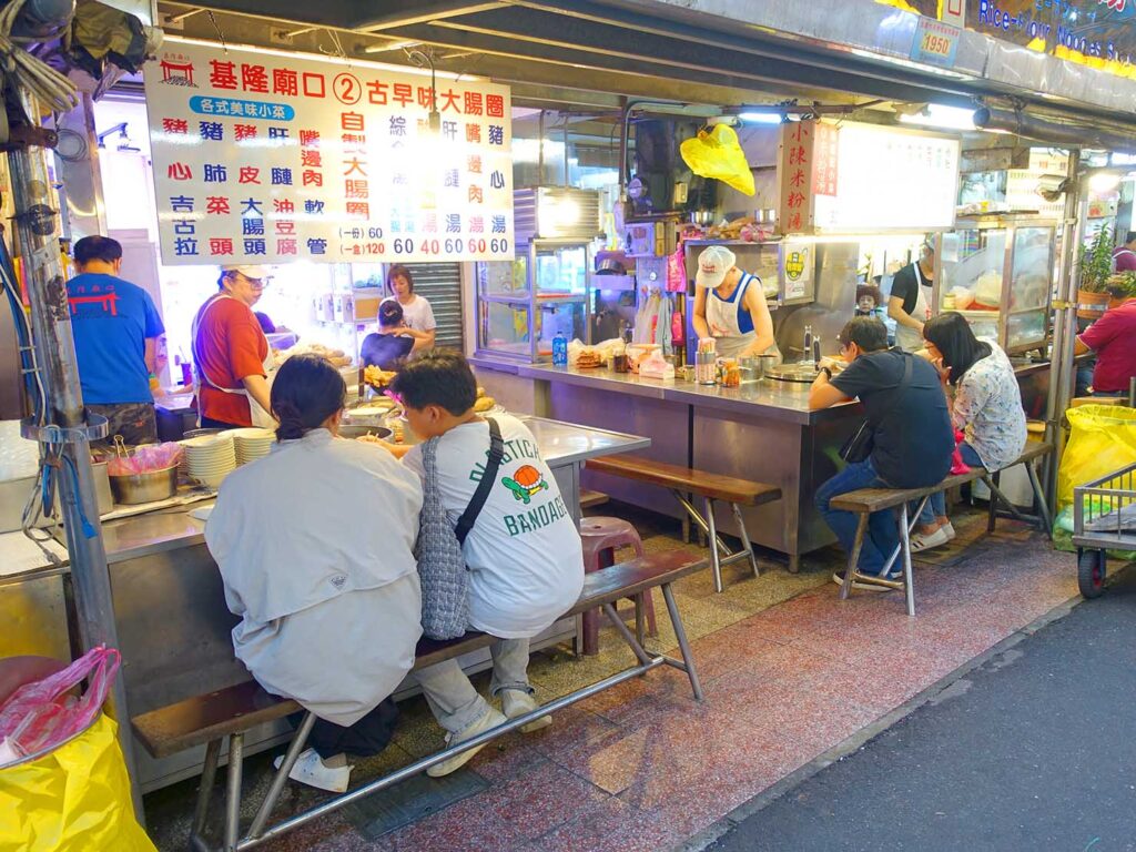 基隆のおすすめスポット「基隆廟口夜市」で食事をする人々